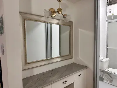 a bathroom with a gold mirror and a sink at Exclusive Group Accomodation in Medellín