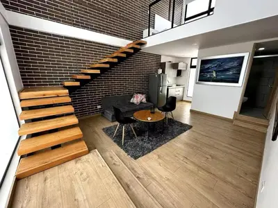 a living room with a staircase and a brick wall at Laureles Garden in Medellín
