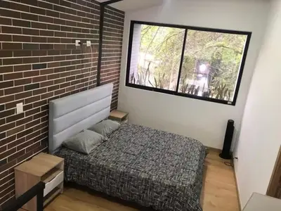 a bedroom with a bed and a brick wall at Laureles Garden in Medellín