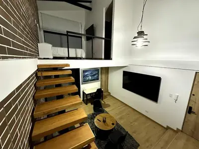 a room with a staircase and a living room with a tv at Laureles Garden in Medellín