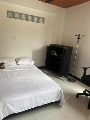 a bedroom with a bed and a desk with a lamp at Apartamento Vista Bella en la mitad de Medellin in Medellín