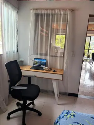 a desk with a laptop and a chair in a room at Apartamento Vista Bella en la mitad de Medellin in Medellín
