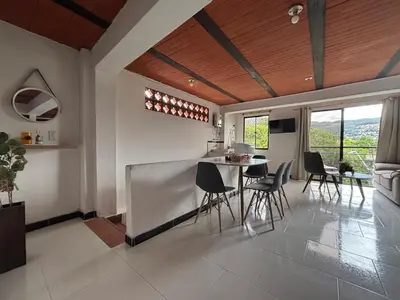a kitchen and living room with a table and chairs at Apartamento Vista Bella en la mitad de Medellin in Medellín