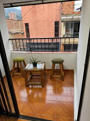 a balcony with two stools and a table on a balcony at Casa del parque in Bello