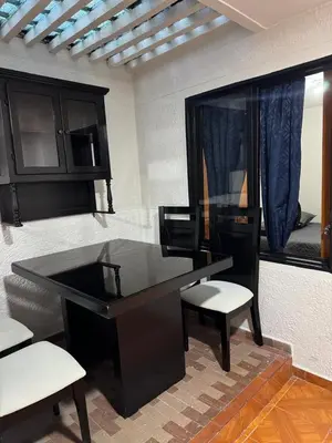 a black desk with two chairs and a mirror at Casa del parque in Bello