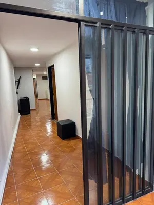 a room with a balcony with glass doors and a floor at Casa del parque in Bello