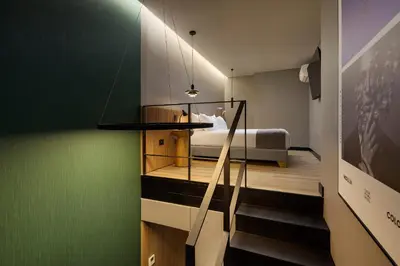a bedroom with a bed and a staircase in a room at Calle Flora Hotel by Jalo in Medellín
