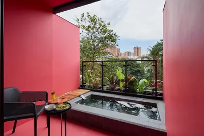 a hot tub in a room with a red wall at Calle Flora Hotel by Jalo in Medellín