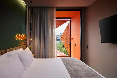 a hotel room with a bed and a window at Calle Flora Hotel by Jalo in Medellín