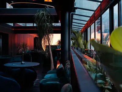 a restaurant with a table and chairs and windows at Calle Flora Hotel by Jalo in Medellín