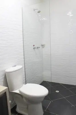 a bathroom with a toilet and a glass shower at Hotel La Bastida in Marinilla
