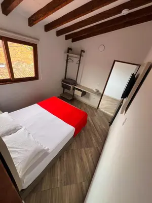 a bedroom with a white bed with a red blanket at Hotel La Bastida in Marinilla
