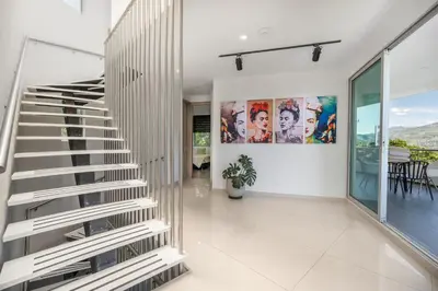 a staircase in a house with white walls at Aurora Ecoliving Finca a 30 minutos de Medellín in Girardota