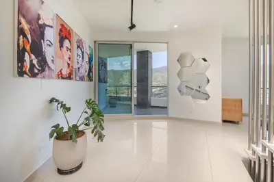 a hallway with a potted plant and paintings on the wall at Aurora Ecoliving Finca a 30 minutos de Medellín in Girardota