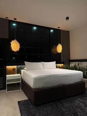 a bedroom with a large bed with two lights at Hostel43 in Estación El Salto