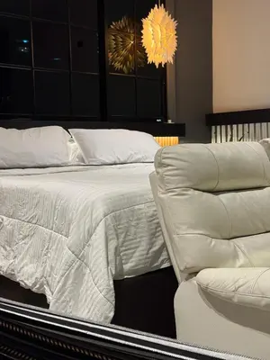 a bedroom with a white bed and a couch at Hostel43 in Estación El Salto