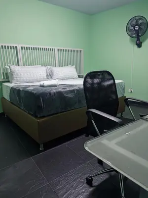 a bedroom with a bed and a chair and a sink at Hostel43 in Estación El Salto