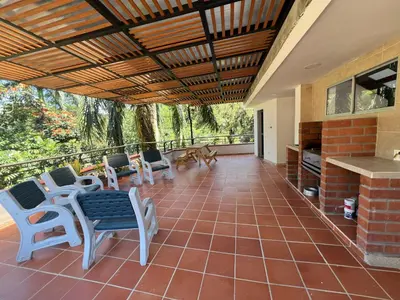 a screened porch with chairs and tables and a table at La terraza 2 in Ciudad Bolívar