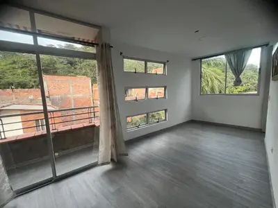 an empty living room with large windows and a balcony at La terraza 2 in Ciudad Bolívar