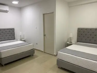 a bedroom with two beds and a door to a door at Apartahotel Provenza 2 in Medellín