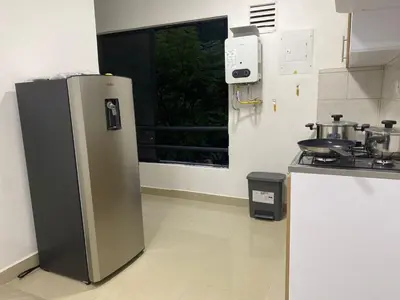 a kitchen with a refrigerator in front of a window at Apartahotel Provenza 2 in Medellín