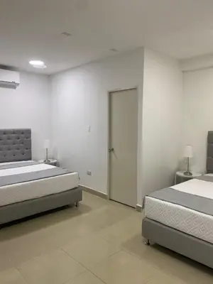 a bedroom with two beds and a sliding door at Apartahotel Provenza 2 in Medellín