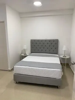 a bed in a room with two tables and two lamps at Apartahotel Provenza 2 in Medellín