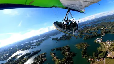 a group of people flying in a helicopter over a lake at El Trebol in Guatapé