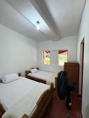 a bedroom with two beds and a fan in it at Hacienda San Rafael en Jericó, Antioquia in Jericó
