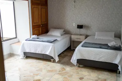 a bedroom with two beds and a window at Casa Laurel Hospedaje Boutique Alojamiento Completo in Medellín