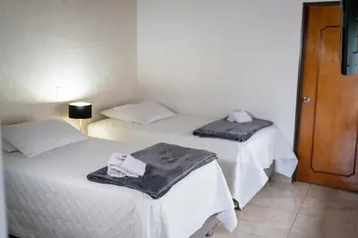 two beds in a hotel room with towels on them at Casa Laurel Hospedaje Boutique Alojamiento Completo in Medellín