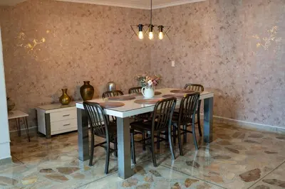 a dining room table with chairs and a vase with flowers at Casa Laurel Hospedaje Boutique Alojamiento Completo in Medellín