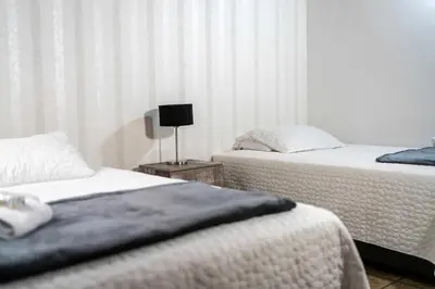 a bedroom with two beds and a lamp on a table at Casa Laurel Hospedaje Boutique Alojamiento Completo in Medellín