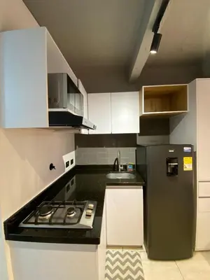 a small kitchen with a stove and a refrigerator at Apartaestudio GoldensMary Buenos Aires in Medellín
