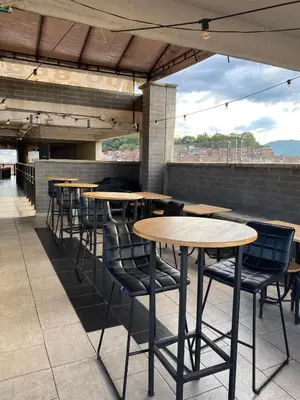 a row of tables and chairs on a rooftop patio at Apartaestudio GoldensMary Buenos Aires in Medellín