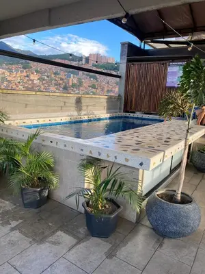 a swimming pool on top of a building with plants at Apartaestudio GoldensMary Buenos Aires in Medellín