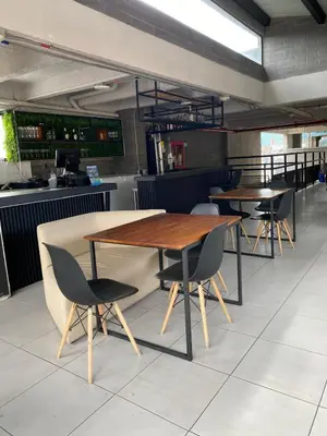 two tables and chairs in a restaurant with a counter at Apartaestudio GoldensMary Buenos Aires in Medellín