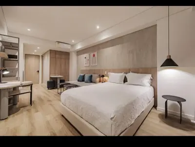 a bedroom with a large white bed and a desk at NEW Loft 38 mt in Laureles, AC, Internet, Jacuzzis, 1 Queen Bed & 1 sofabed in Medellín