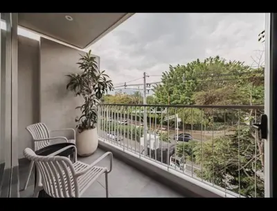 a balcony with a table and chairs and a window at NEW Loft 38 mt in Laureles, AC, Internet, Jacuzzis, 1 Queen Bed & 1 sofabed in Medellín