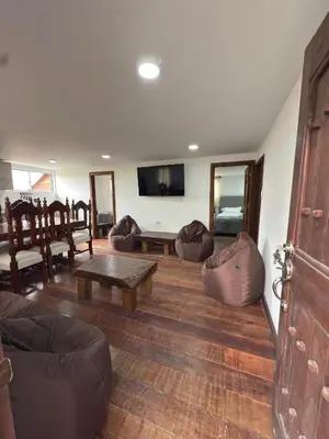 a living room with couches and a table and a tv at Casa Campestre Los Nevados Patio Bonito in Estación El Salto