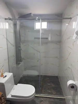 a bathroom with a toilet and a glass shower at Casa Campestre Los Nevados Patio Bonito in Estación El Salto