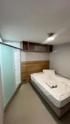 a bedroom with a bed and a glass wall at new apartment in front of the park in Medellín