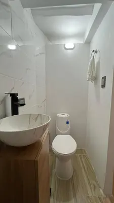 a bathroom with a bowl sink and a toilet at new apartment in front of the park in Medellín