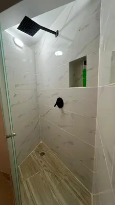 a shower with a black cat sitting on the wall at new apartment in front of the park in Medellín