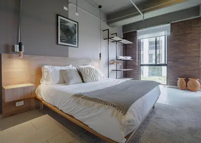 a bedroom with a large bed and a large window at Cozy and Bright Studio Loft in Central Laureles in Medellín