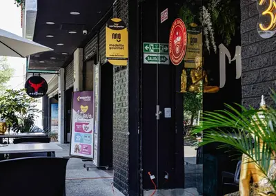 a door to a restaurant with signs on it at Cozy and Bright Studio Loft in Central Laureles in Medellín