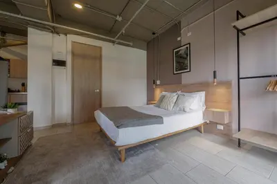 a bedroom with a large bed in a room at Cozy and Bright Studio Loft in Central Laureles in Medellín