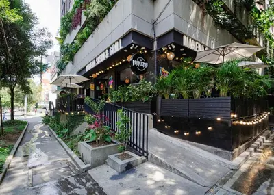 a restaurant with plants on the side of a building at Cozy and Bright Studio Loft in Central Laureles in Medellín