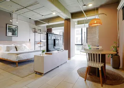 a living room with a bed and a table at Cozy and Bright Studio Loft in Central Laureles in Medellín