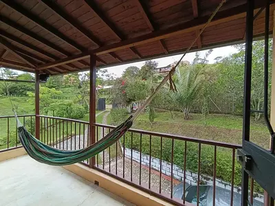a hammock on a balcony with a view of a yard at Alma Guatapé in Guatapé
